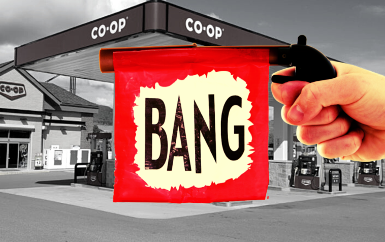 A toy gun in from of a backdrop of a co-op gas station