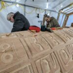 Stan Hunt and his nephew Curtis Dickie working on the Indian Residential School Memorial Monument. This significant project involved the hand-carving of 130 individual faces, representing the children who suffered or never came home from the Indian Residential Schools.