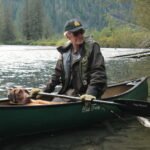 A man with a dog on a canoe