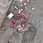 A pile of scrap metal next to a derelict barge at the Deep Water Recovery site.