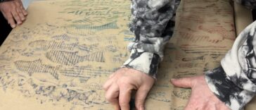 A person creating a fish rubbing