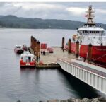 A red Canadian Coast Guard vessel reloading at a dock