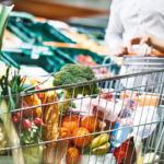 A couple shopping for groceries and pushing a trolley cart